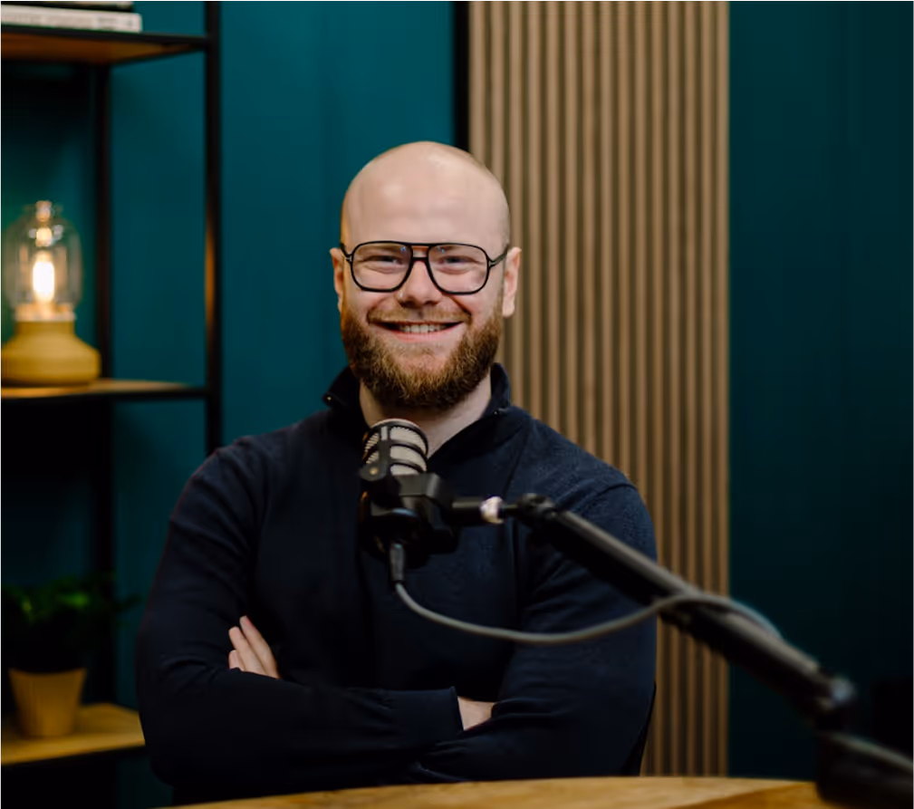Gast aan tafel achter een microfoon in de podcaststudio van Onruststokerz in Roermond